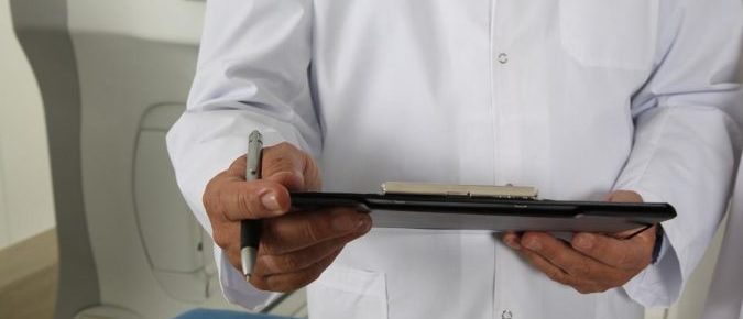A close up of a doctor holding a clipboard