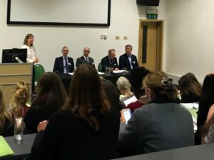 Four panellists debate in front of an audience at Enable Law event