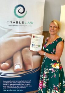 Photo of Enable Law's Claire Stoneman holding the Foundation for Infant Loss certificate