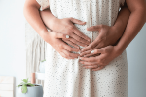Photo of a pregnant woman with hands resting on her baby bump
