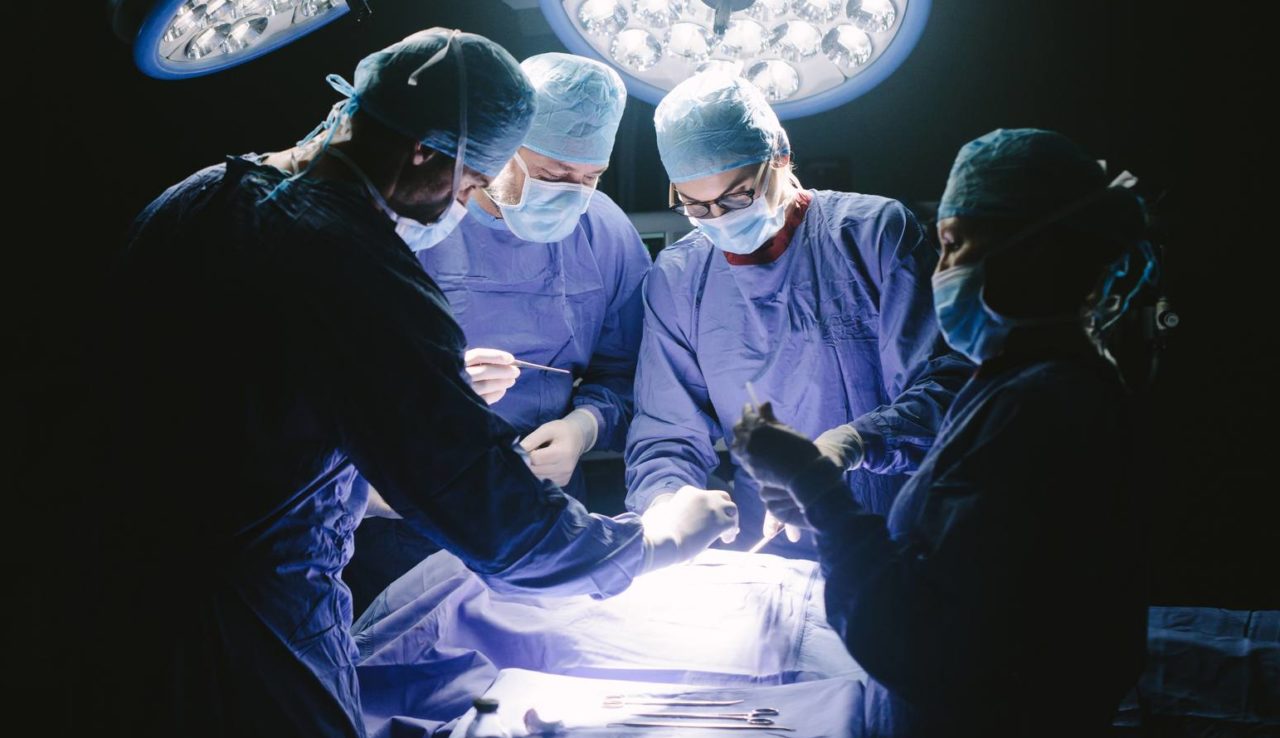 Doctors during surgery on patient in hospital. Surgeons team working at the hospital performing surgical procedure in operating theatre.