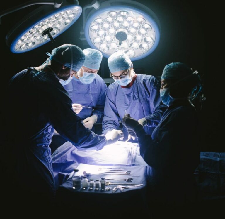 Doctors during surgery on patient in hospital. Surgeons team working at the hospital performing surgical procedure in operating theatre.