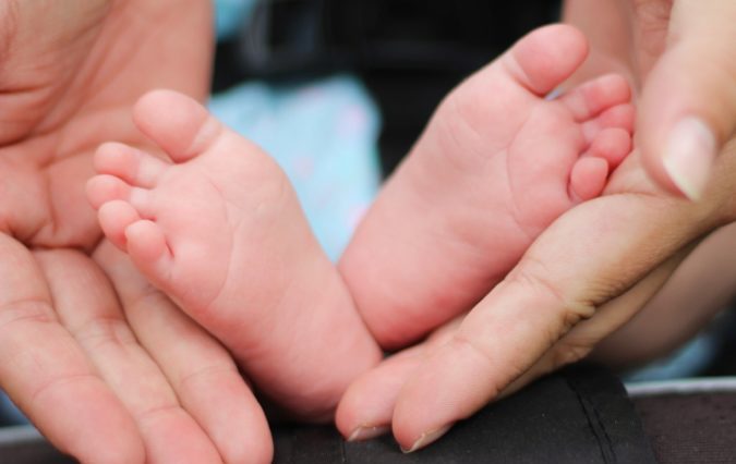 Photo of hands holding a babys feet