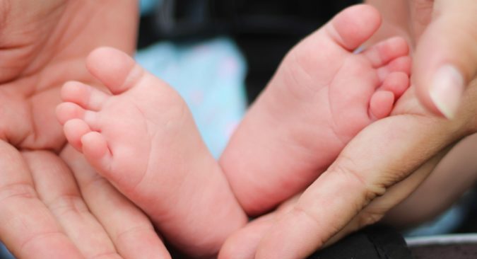 Photo of hands holding a babys feet