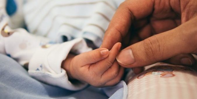 Baby holding mum's hand