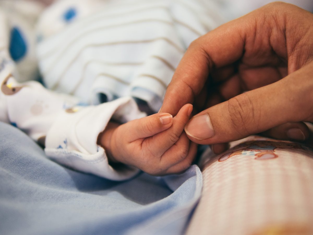 Parent holding tiny baby's hand