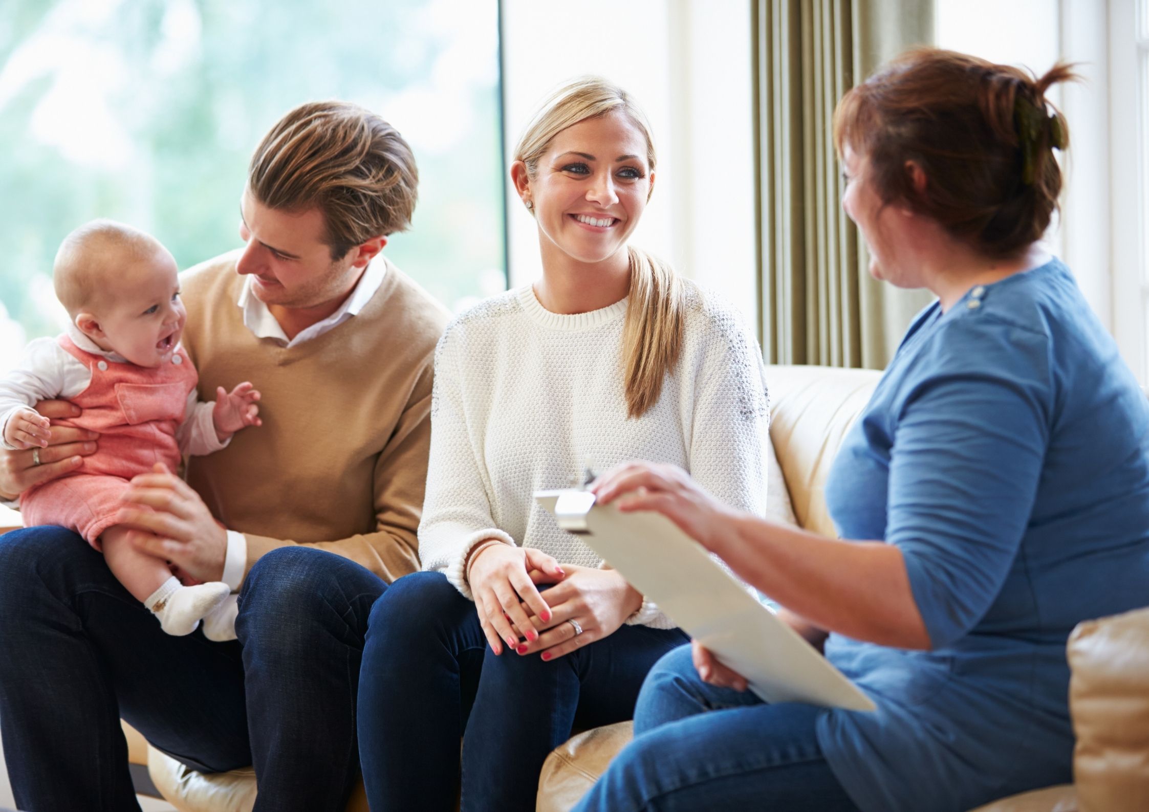 A health visitor and a family on a sofa