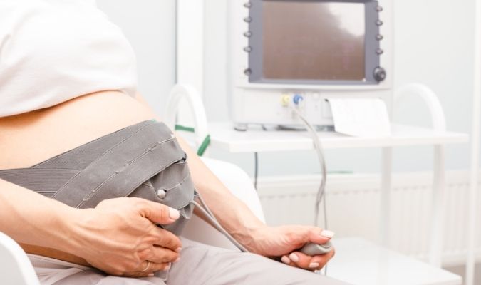 Pregnant woman having her heart monitored