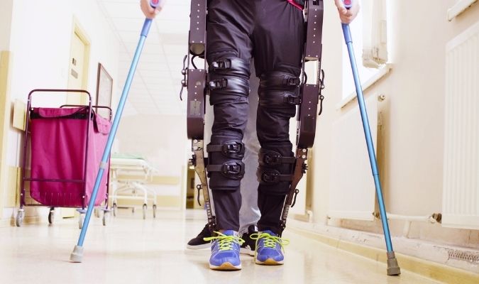 Someone using an assistive exoskeleton to walk