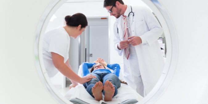 A doctor and a nurse preparing a patient for a CT scan