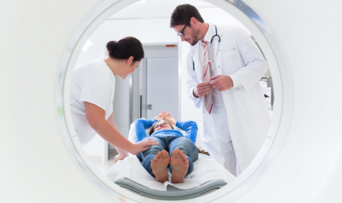 A doctor and a nurse preparing a patient for a CT scan
