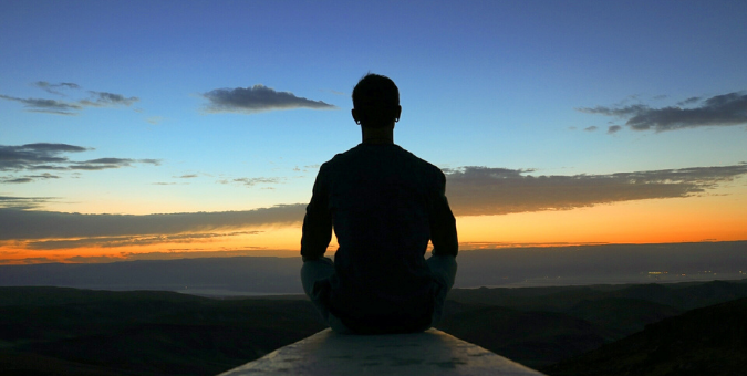 A man meditating while looking out to sea