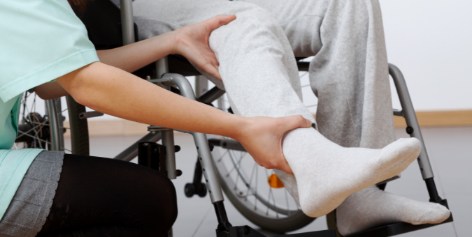 A person in a wheelchair doing leg rehabilitation exercises