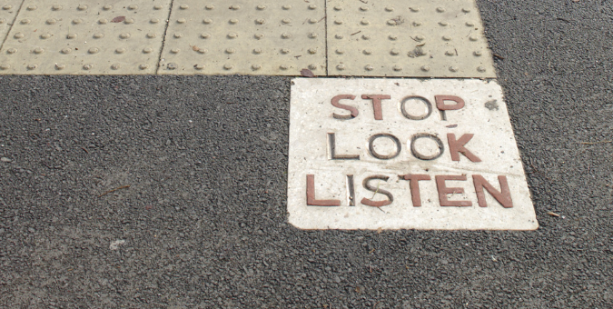Stop look listen road crossing message on a paving slab
