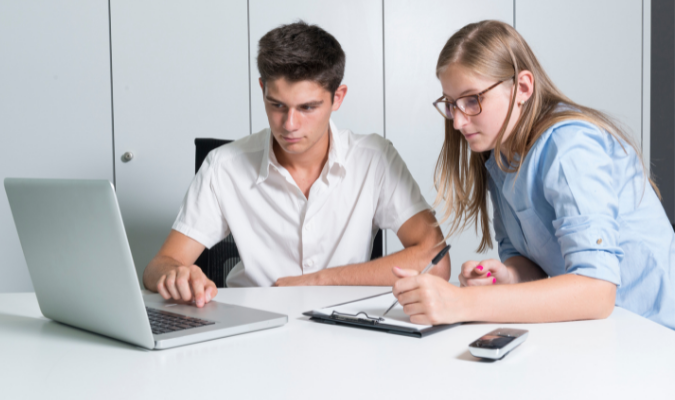 Adult and teenager looking at a laptop