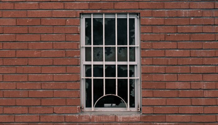 A barred window on a red brick house