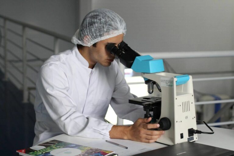 A scientist looks at a sample through a microscope