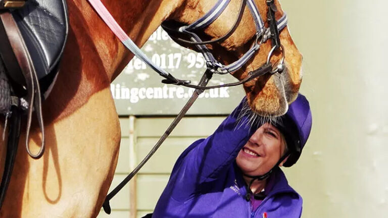 A woman strokes a horse