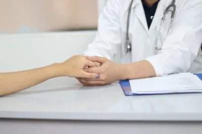 A doctor and patient holding hands